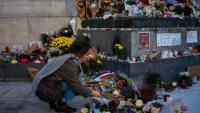 Une femme dépose des fleurs en hommage aux victimes du 13 novembre 2015, Place de la République à Paris, le 11 novembre 2025