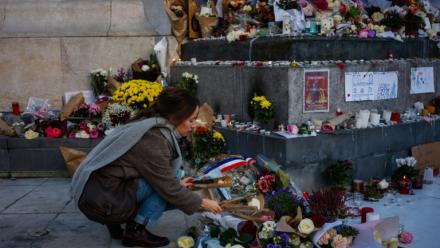 Une femme dépose des fleurs en hommage aux victimes du 13 novembre 2015, Place de la République à Paris, le 11 novembre 2025