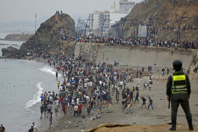 Des personnes sont rassemblées le long d'une clôture près de Fnideq, à la frontière entre le Maroc et l'Espagne, le 31 juillet 2026