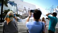 Des passants photographient la façade du Palais du festival à Cannes le 11 mai 2026