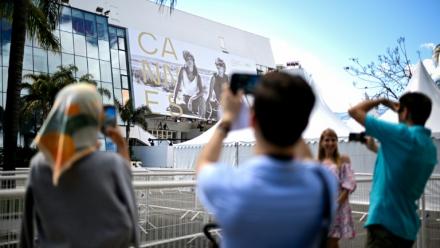 Des passants photographient la façade du Palais du festival à Cannes le 11 mai 2026