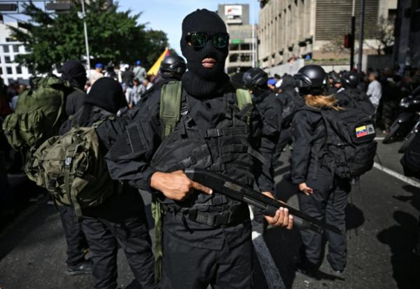 Des partisans armés du président vénézuélien Nicolás Maduro se rassemblent près du palais présidentiel de Miraflores à Caracas le 3 janvier 2026