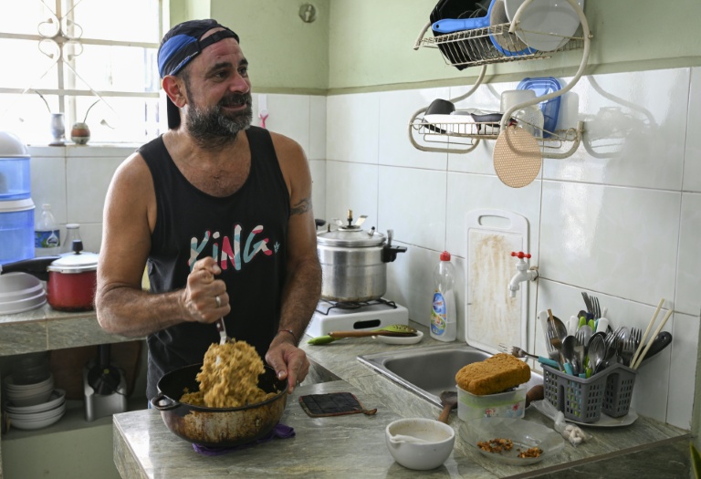 Roberto Ronda cuisine à son domicile pour le petit commerce de repas qu'il a lancé, le 31 juillet 2026 à La Havane 