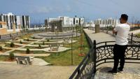 Un homme observe le nouveau projet de logements en construction dans le quartier d'Al-Salam à Derna, le 17 mai 2026, dans le cadre du plan de reconstruction de la ville, près de trois ans après le passage dévastateur d'une tempête qui a fait près de 4 000 victimes