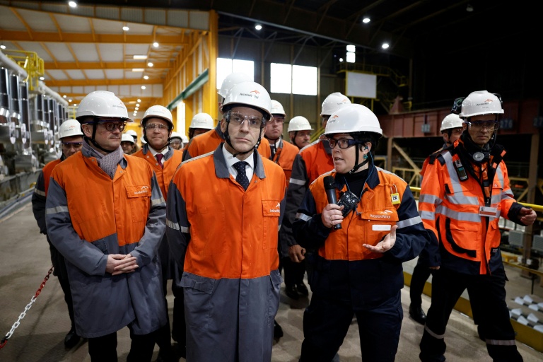 Le président Emmanuel Macron (g) écoute une employée (d) lors de la visite du site d'ArcelorMittal à Dunkerque (Nord), le 10 février 2026