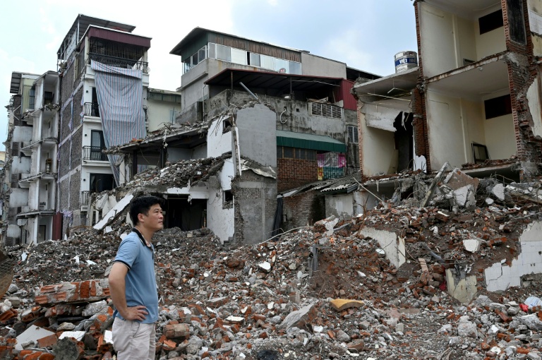 Un homme regarde sa maison démolie dans le cadre de grands travaux décidés par les autorités pour la capitale vietnamienne Hanoï, le 20 mai 2026