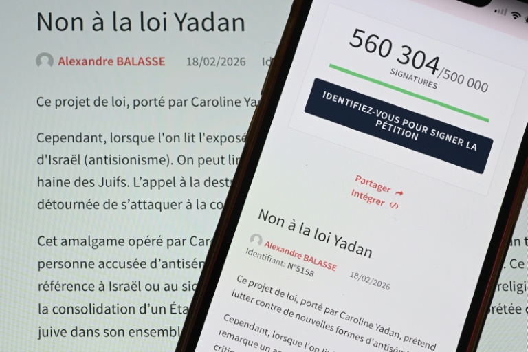 Cette photo prise le 8 avril 2026 à Mulhouse, dans l'est de la France, montre un smartphone et un écran d'ordinateur affichant une page du site web de l'Assemblée nationale française indiquant qu'une pétition intitulée 