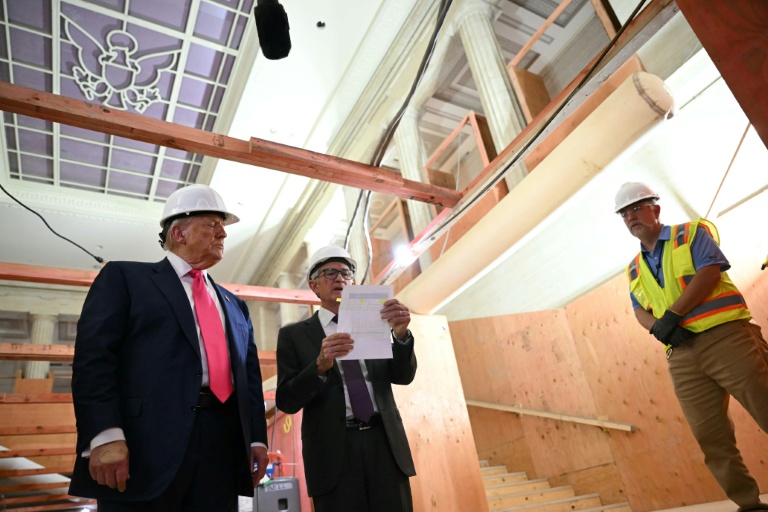 Le président américain Donald Trump (g), le président de la Réserve fédérale (Fed), Jerome Powell (c) et le chef de projet (d), visitent le chantier de rénovation du siège de la Fed, le 24 juillet 2025 à Washington