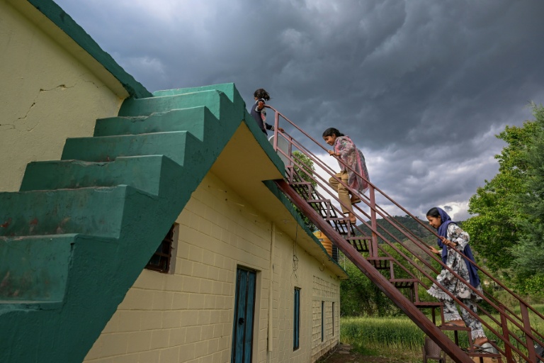 Des enfants montent sur le toit d'une maison dans le village de Kasaliyan, près de la frontière avec le Pakistan, le 6 avril 2026 en Inde