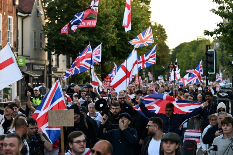 Des manifestants appelant à la fermeture de l'hôtel Bell, qui héberge des demandeurs d'asile, marchent vers les bureaux du conseil municipal d'Epping, au nord-est de Londres, le 31 août 2025