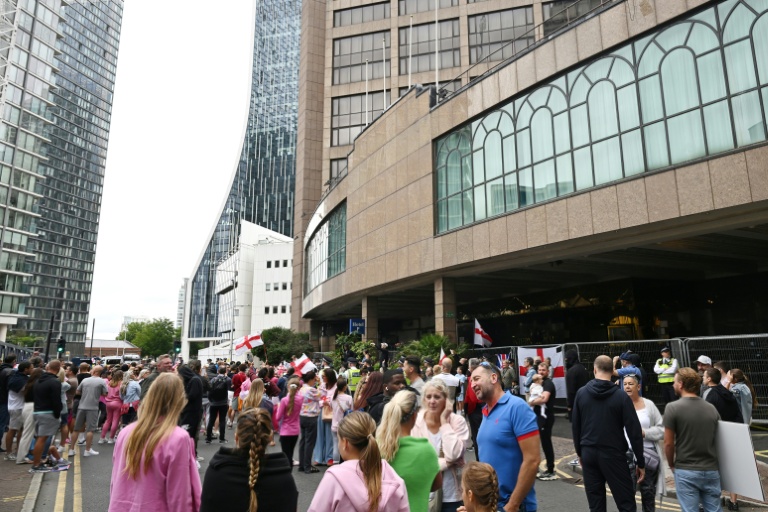 Des manifestants rassemblés devant l'hôtel Britannia qui héberge des demandeurs d'asile à Canary Wharf, le 3 août 2025 à Londres