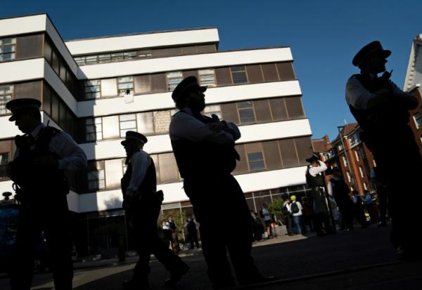 Des policiers devant l'hôtel Thistle Barbican à Londres, qui héberge des demandeurs d'asile, le 8 août 2025, avant des manifestations de l'extrême droite