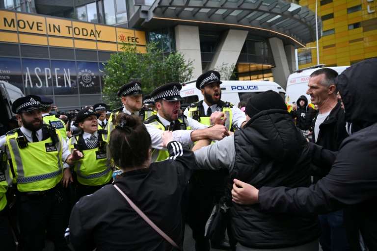 La police repousse des manifestants devant l'hôtel Britannia hébergeant des demandeurs d'asile à Canary Wharf, le 3 août 2025 à Londres