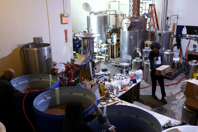 Siavash Karampour (à droite) et Sasan Oskouei (au centre) fabriquent une eau-de-vie traditionnelle iranienne appelée aragh sagi, dans une distillerie de Yonkers, dans l'État de New York, le 21 avril 2026