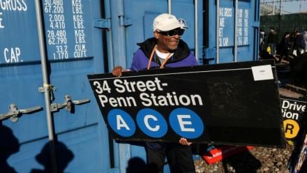 Le réalisateur Spike Lee tient une panneau d'une station de métro qu'il vient d'acheter lors de la vente annuelle organisée par la régie des transports de New York (MTA), le 9 octobre 2026
