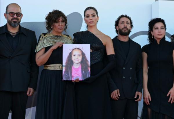 L'acteur israélien Amer Hlehel (g), la réalisatrice franco-tunisienne Kaouther Ben Hania, l'actrice Saja Kilani, l'acteur Motaz Malhees et la comédienne Clara Khoury posent avec un portrait de la fillette palestinienne Hind Rajab, pour la projection officielle du film "The Voice of Hind Rajab", en lice pour le Lion d'or de la 82e Mostra de Venise, le 3 septembre 2025