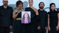 L'acteur israélien Amer Hlehel (g), la réalisatrice franco-tunisienne Kaouther Ben Hania, l'actrice Saja Kilani, l'acteur Motaz Malhees et la comédienne Clara Khoury posent avec un portrait de la fillette palestinienne Hind Rajab, pour la projection officielle du film "The Voice of Hind Rajab", en lice pour le Lion d'or de la 82e Mostra de Venise, le 3 septembre 2025