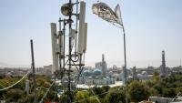 Un drapeau taliban près d'un équipement de télécommunication installé sur un toit fournissant des services Internet à Mazar-i-Sharif, le 16 septembre 2025, alors que l'administration talibane a interdit l'Internet par fibre optique dans la province de Balkh