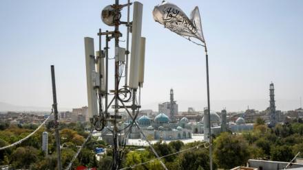 Un drapeau taliban près d'un équipement de télécommunication installé sur un toit fournissant des services Internet à Mazar-i-Sharif, le 16 septembre 2025, alors que l'administration talibane a interdit l'Internet par fibre optique dans la province de Balkh