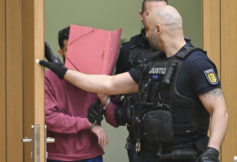 L'accusé (g) arrive dans la salle d'audience du tribunal régional de Stuttgart-Stammheim, dans le sud de l'Allemagne, le 13 février 2025