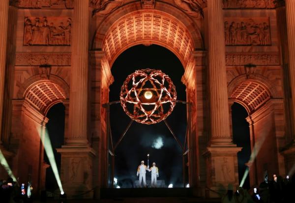 Les légendes italiennes du ski Deborah Compagnoni et Alberto Tomba allument la vasque olympique sous l'Arc de la paix à Milan, lors de la cérémonie d'ouverture des Jeux de Milan Cortina, le 6 février 2026