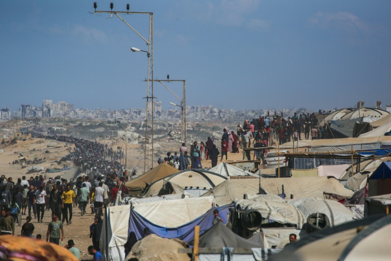 Des Palestiniens marchent sur la route al-Rachid en direction de la ville de Gza, depuis Nousseirat dans le centre de la bande de Gaza, le 10 octobre 2025.
