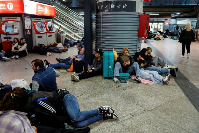 Des voyageurs se préparant à passer la nuit à la gare d'Atocha, à Madrid, à cause de la panne d'électricté géante, le 28 avril 2025