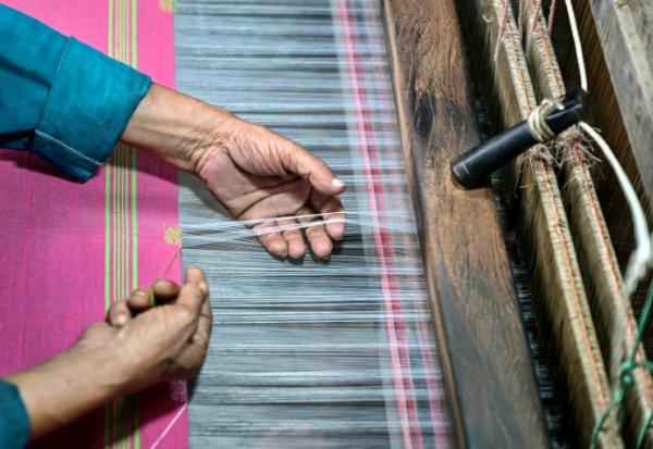 Un artisan travaille sur un métier à tisser traditionnel dans un atelier de Tangail, le 2 mars 2026 au Bangladesh