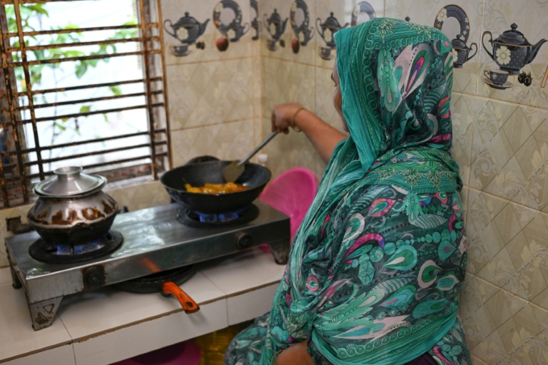 Nargis Begum cuisine à son domicile, le 12 août 2026 à Brahmanbaria, dans l'est du Bangladesh 