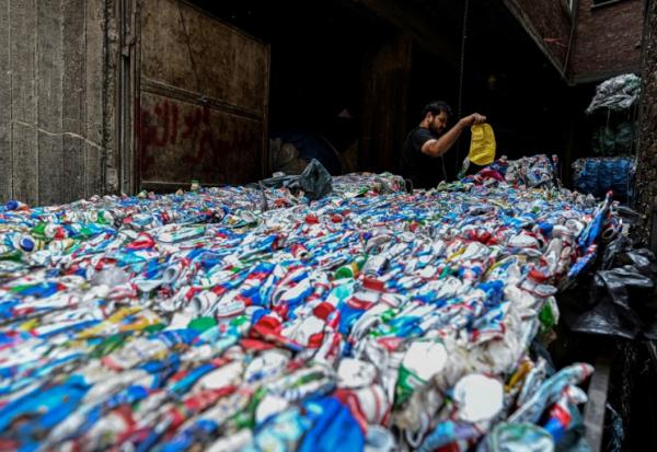 Un ouvrier égyptien conditionne du plastique destiné à être recyclé dans une usine de la "ville des déchets, dans le quartier de Manshiyet Nasser, au Caire le 6 juillet 2026