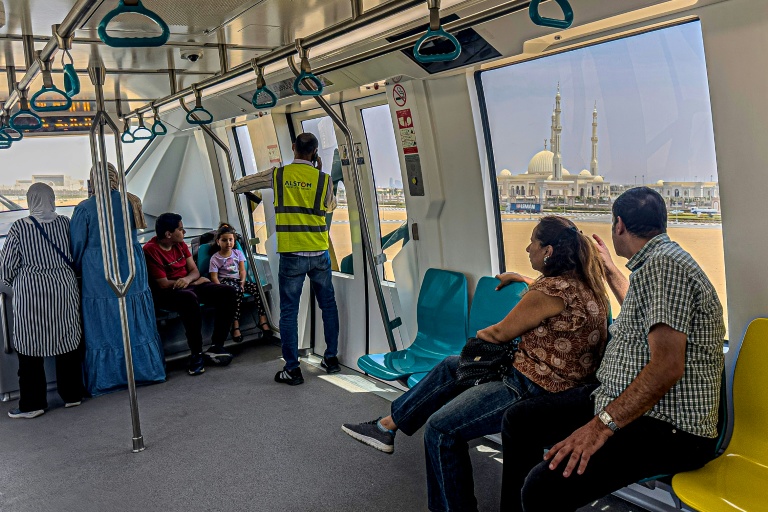 Des passagers à bord du monorail récemment inauguré près de la grande mosquée al-Fattah al-Alim  dans la nouvelle capitale administrative, à l'est du Caire, le 22 mai 2026, en Egypte
