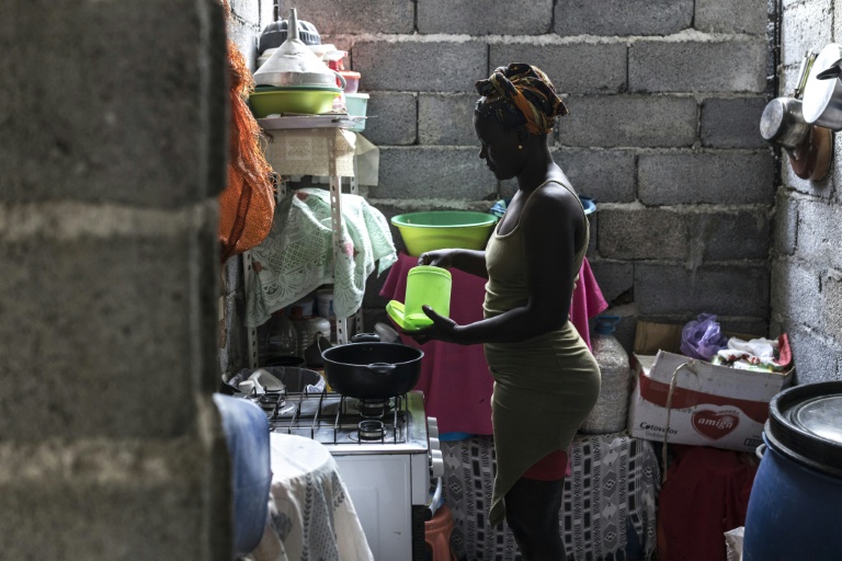 Vania Tavares cuisine chez elle avant de se rendre à la plage pour extraire du sable noir destiné à la vente, à Charco, le 20 mai 2026 au Cap-Vert