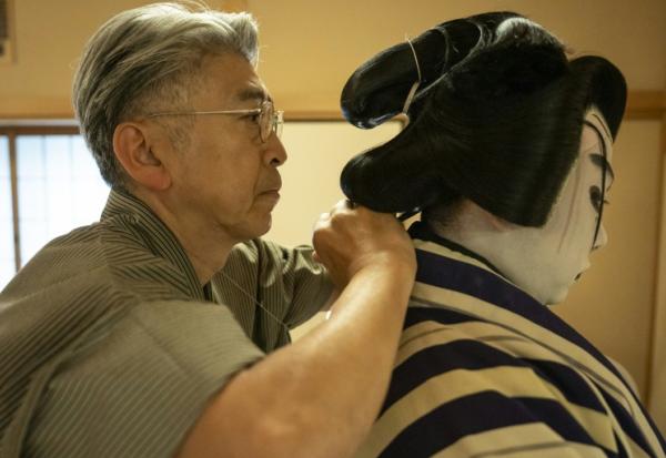 Le maître perruquier Tadashi Kamoji (g) aide l'acteur Tanenosuke Nakamura à mettre sa perruque avant une représentation au théâtre Kabuki-za à Tokyo, le 13 avril 2026