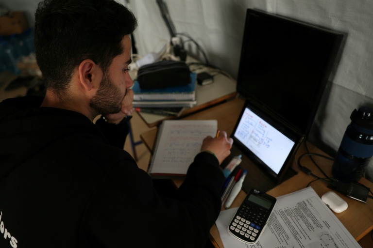 Un jeune homme poursuit ses études en ligne dans une école publique transformée en refuge pour personnes déplacées, à Dekwaneh, au nord de Beyrouth, le 25 mars 2026 au Liban