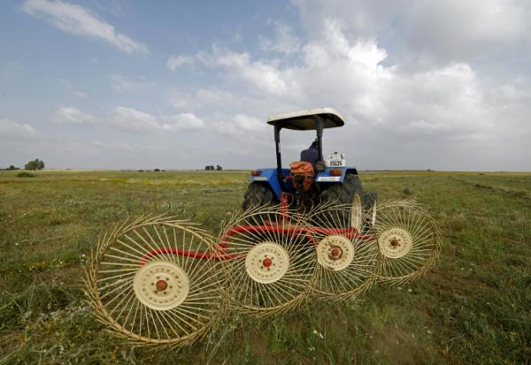 Un agriculteur utilise une machine de ramassage du foin dans un champ de la région de Zehiliga, au Maroc, le 28 avril 2026