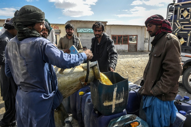 Des vendeurs remplissent des jerricans de carburant iranien de contrebande, à la périphérie de Quetta, dans la province du Baloutchistan, au Pakistan le 14 mars 2026