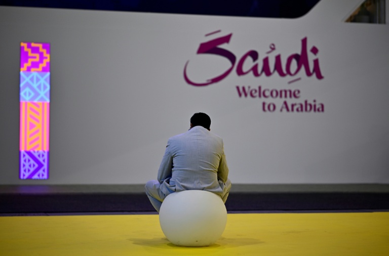 Un visiteur assis devant le stand de l'Arabie saoudite à l'ouverture du salon du tourisme ITB à Berlin, le 3 mars 2026