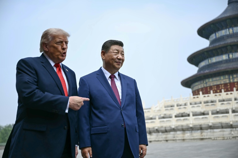 Le président américain Donald Trump (g) et le président chinois Xi Jinping visitent le Temple du Ciel à Pékin, le 14 mai 2026