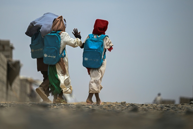 Une fillette, amputée de son bras droit après avoir été blessée pendant la guerre, sort de l'école gérée en partenariat avec l'Unicef dans un camp de personnes déplacées, près de Port-Soudan, le 26 avril 2026 au Soudan