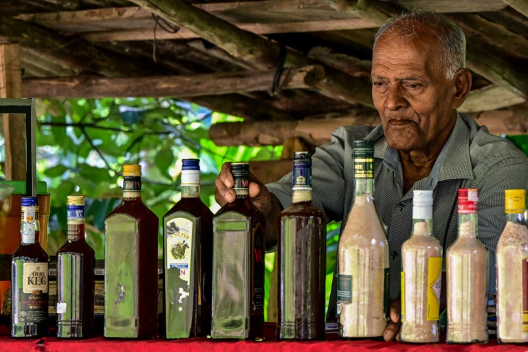 Un vendeur dispose des produits fabriqués à partir de la sève de kithul, dans le village d'Ambegoda, le 26 janvier 2026 au Sri Lanka