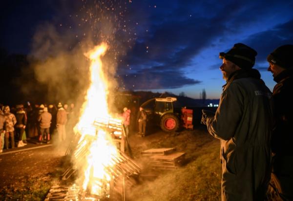 Des agriculteurs se réchauffent autour d'un feu, près de Léguevin (Haute-Garonne), le 7 janvier 2026 