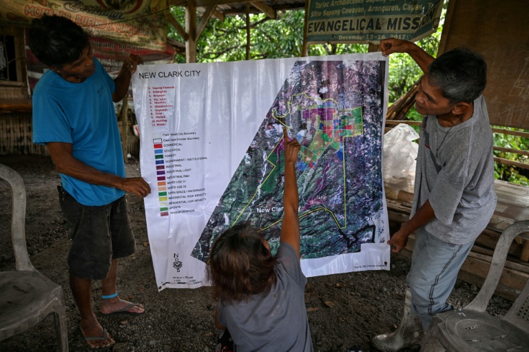 Des habitants désignent sur une carte un vaste projet de pôle technologique à l'initiative des Etats-Unis qui menacerait une tribu d'expulsion, le 2 septembre 2026 à Capas, aux Philippines
