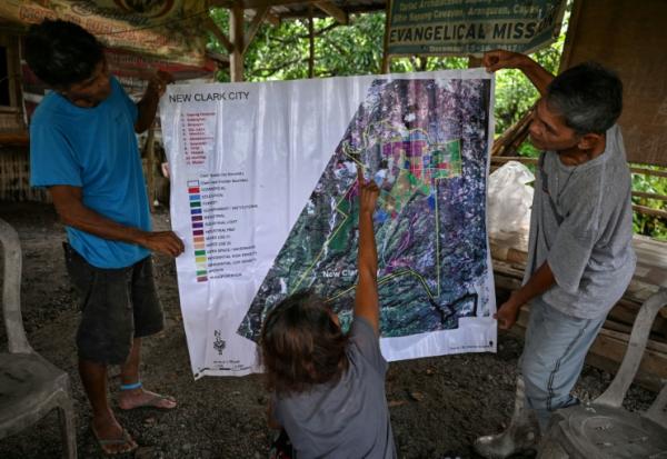 Des habitants désignent sur une carte un vaste projet de pôle technologique à l'initiative des Etats-Unis qui menacerait une tribu d'expulsion, le 2 septembre 2026 à Capas, aux Philippines
