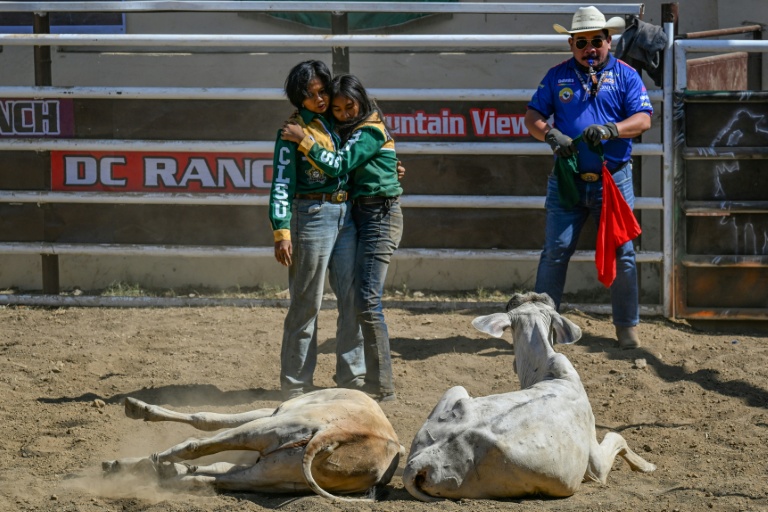 Christel Mae Firme (G) et sa partenaire après avoir concouru lors d'une compétition de rodéo organisée dans la province philippine de Masbate, le 15 avril 2026