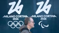 Une personne passe devant les logos des Jeux olympiques et paralympiques d'hiver de Milan Cortina, à Milan, le 5 février 2026