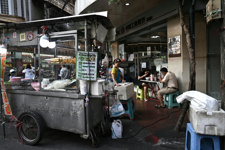 Des gens attablés dans un restaurant de rue, le 29 avril 2026 à Bangkok 