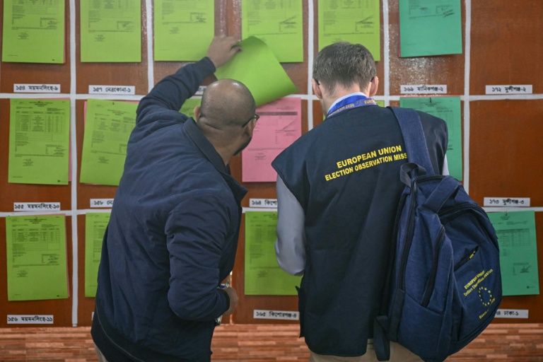 Des membres des médias consultent des documents sur les résultats préliminaires des élections législatives au bureau de la Commission électorale à Dacca, le 13 février 2026 au Bangladesh