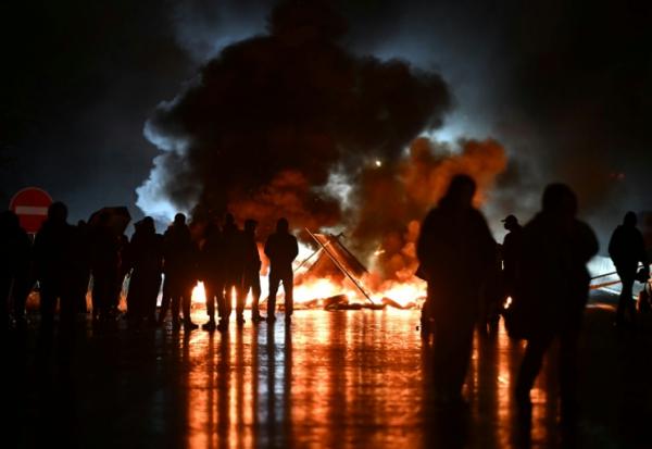 Des manifestants du mouvement "Bloquons tout" près d'objets en feu sur le viaduc de Calix, le 10 septembre 2025