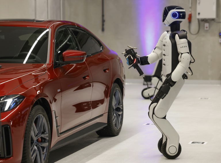 Le robot humanoïde AEON, fabriqué par l'entreprise Hexagon, présenté par le constructeur automobile BMW alors qu'il  travaille sur une voiture avec un scanner laser, à Munich (Allemagne), le 27 février 2026