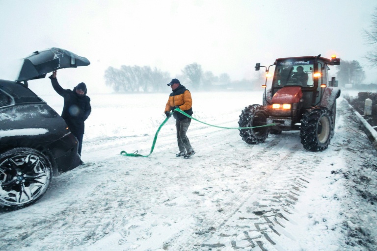 Un agent municipal s'apprête à tracter une voiture piégée par la neige, le 7 janvier 2026 à Sebourg, dans le Nord